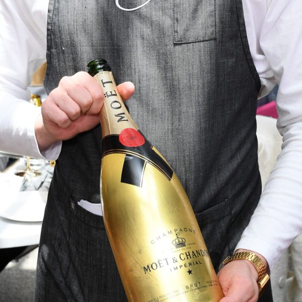 Waiter with a bottle of champagne ate love.fish restaurant